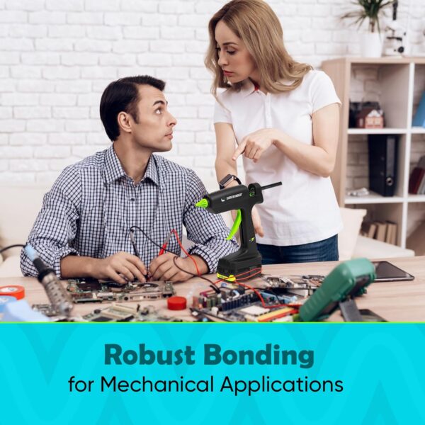 Two people working at a table with one person focused on electronics assembly while the SpliSeal 120W glue gun sits nearby, ready for use.