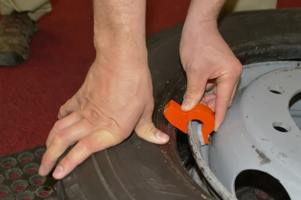 Pneu-Tek Bead Keeper holding tire bead in drop center during mounting process